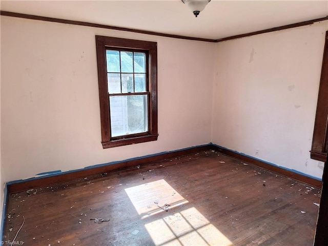 spare room featuring hardwood / wood-style flooring and ornamental molding