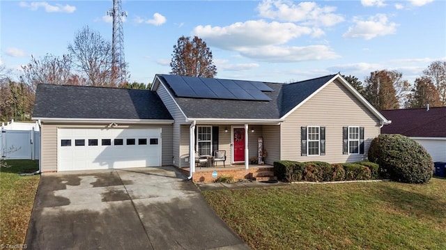 ranch-style home featuring covered porch, a garage, a front yard, and solar panels