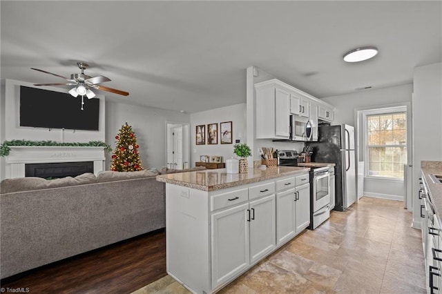 kitchen featuring ceiling fan, light wood-type flooring, white cabinetry, and stainless steel appliances