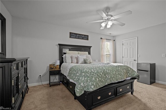 bedroom with stainless steel fridge, ceiling fan, and light carpet