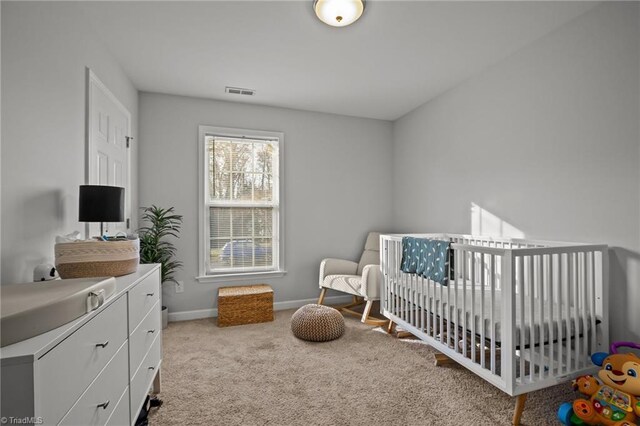 bedroom featuring a crib and light carpet