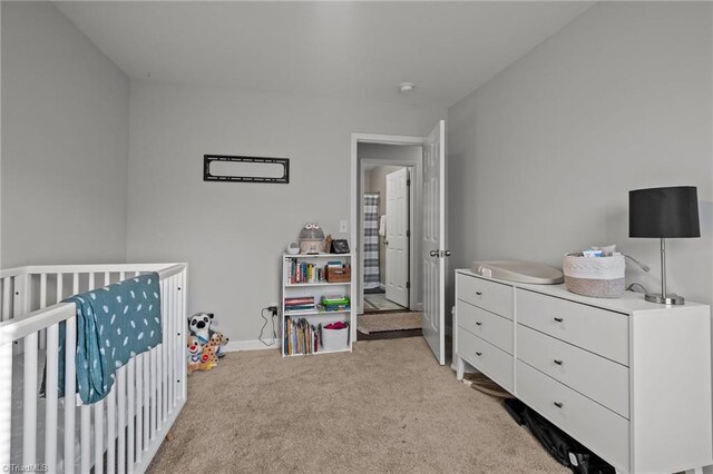 bedroom featuring light colored carpet and a crib