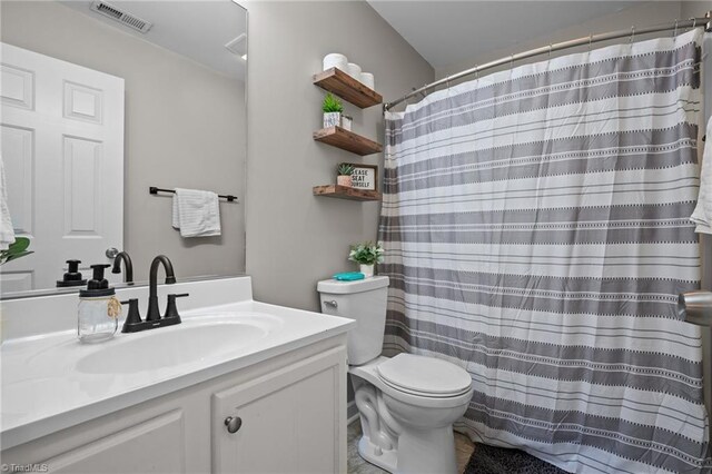 bathroom featuring vanity, curtained shower, and toilet