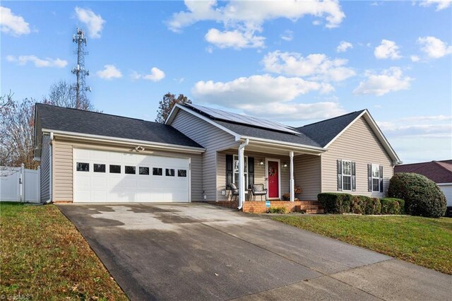 ranch-style home featuring a front lawn, a garage, a porch, and solar panels