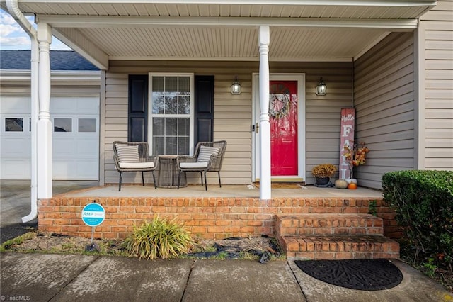 entrance to property featuring a porch and a garage