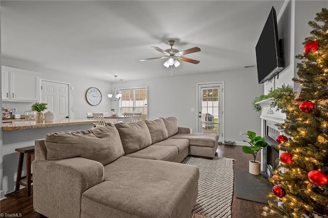 living room with dark hardwood / wood-style floors, ceiling fan with notable chandelier, and a wealth of natural light