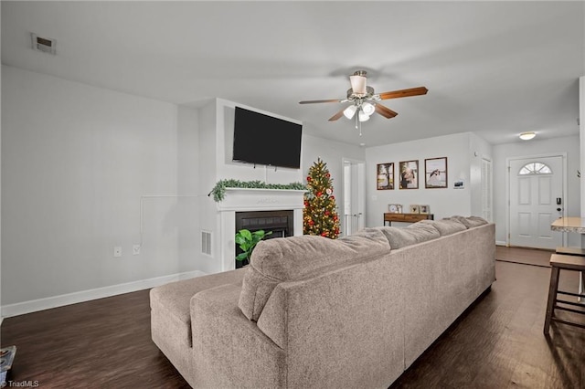 living room featuring ceiling fan and dark hardwood / wood-style flooring