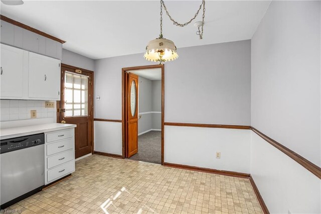 kitchen with baseboards, dishwasher, light countertops, white cabinetry, and backsplash