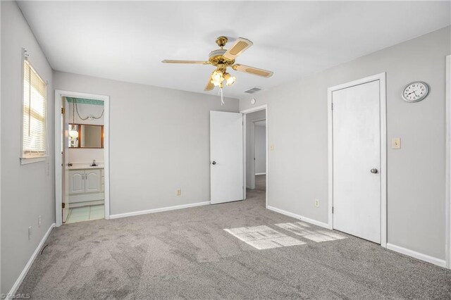 unfurnished bedroom with baseboards, visible vents, carpet flooring, and ensuite bathroom