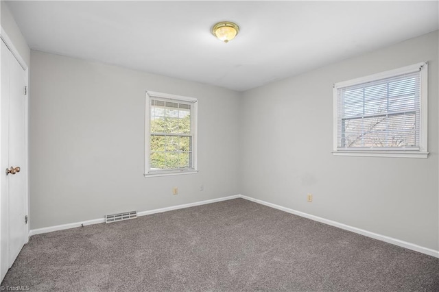 unfurnished bedroom featuring carpet floors, baseboards, visible vents, and a closet