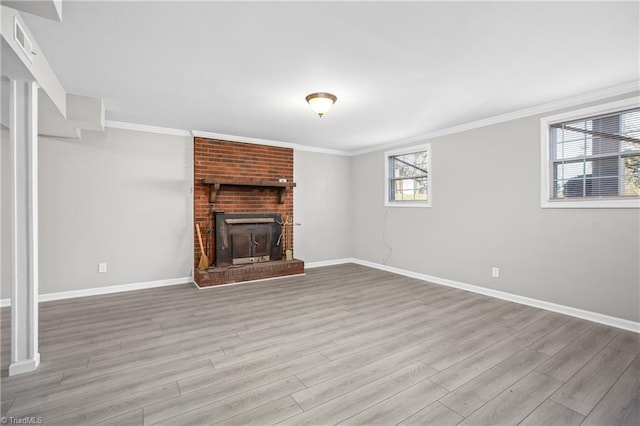 unfurnished living room featuring visible vents, baseboards, wood finished floors, crown molding, and a fireplace