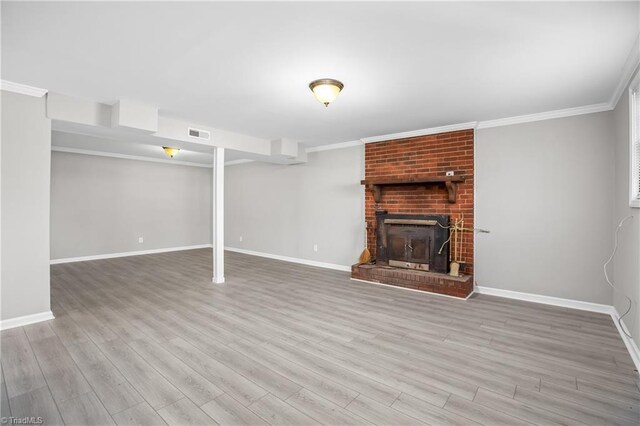 unfurnished living room with ornamental molding, visible vents, a fireplace, and wood finished floors