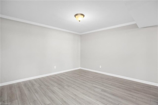 unfurnished room featuring ornamental molding, baseboards, and wood finished floors