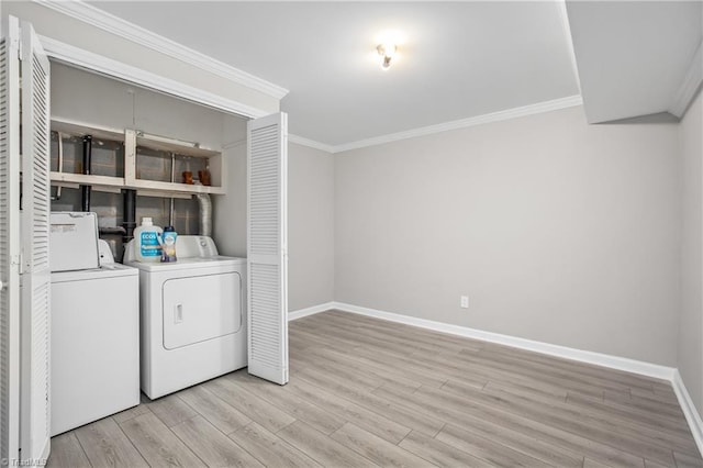 washroom featuring crown molding, light wood finished floors, washing machine and dryer, laundry area, and baseboards