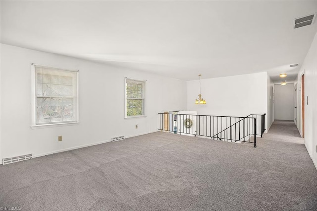 carpeted empty room with visible vents