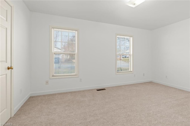 unfurnished room with light carpet, baseboards, and visible vents