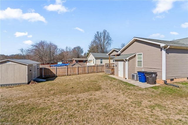 view of yard featuring a fenced backyard, an outdoor structure, central AC, and a shed