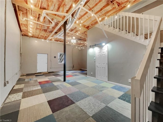 below grade area with tile patterned floors, stairway, and baseboards