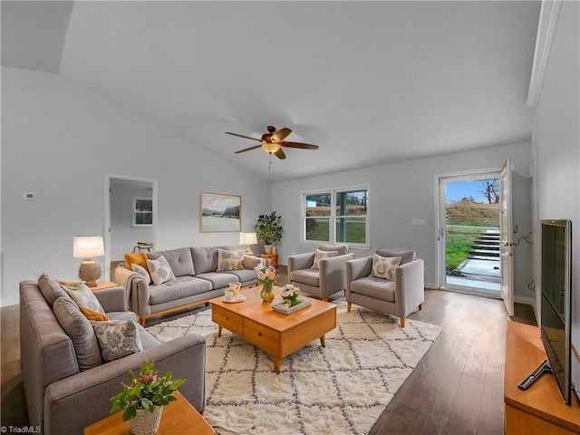 living room featuring a wealth of natural light, wood finished floors, ceiling fan, and vaulted ceiling