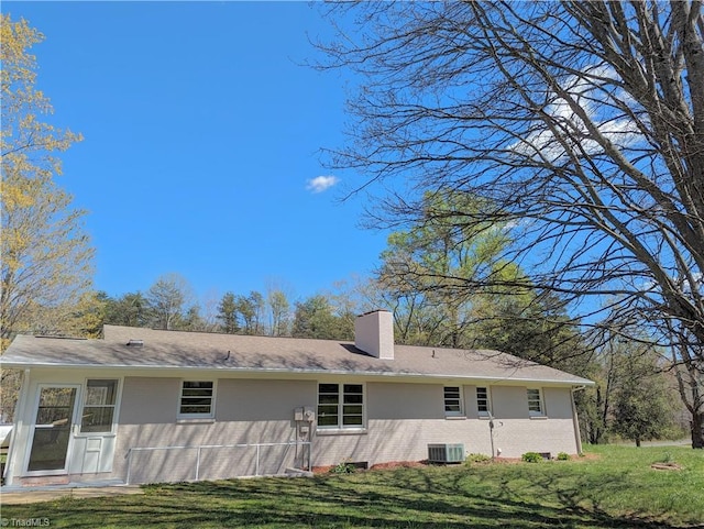 rear view of property with a yard and central AC unit