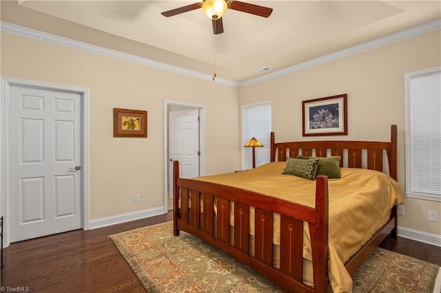 bedroom featuring a raised ceiling, crown molding, wood finished floors, and baseboards