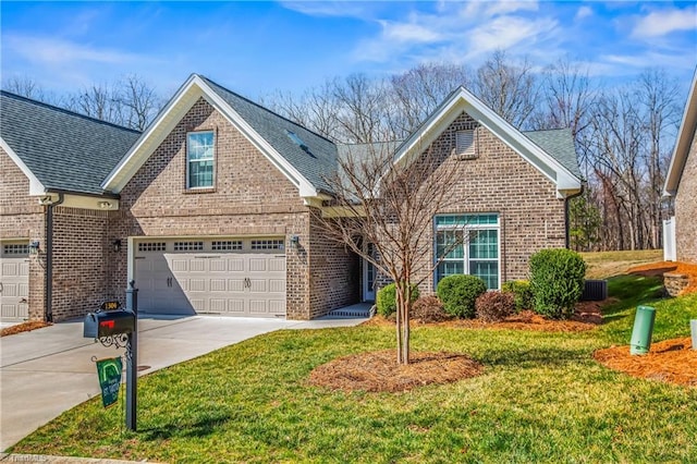 traditional home featuring brick siding, concrete driveway, a front lawn, and a shingled roof