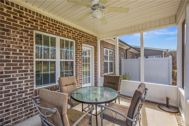 sunroom with wood ceiling and a ceiling fan