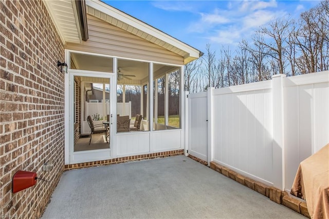 view of patio / terrace featuring fence and a sunroom