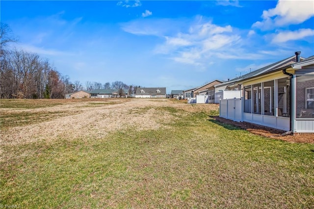 view of yard with a residential view and a sunroom