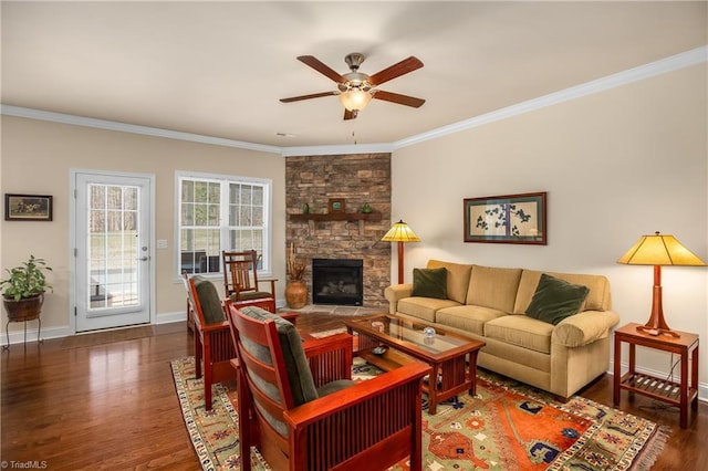 living area with a ceiling fan, wood finished floors, baseboards, a fireplace, and ornamental molding