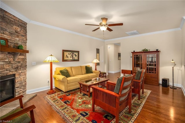 living area with a stone fireplace, wood finished floors, visible vents, and baseboards