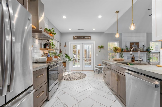 kitchen featuring french doors, sink, hanging light fixtures, appliances with stainless steel finishes, and tasteful backsplash