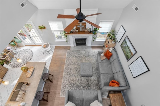 living room featuring ceiling fan, wood-type flooring, and a fireplace