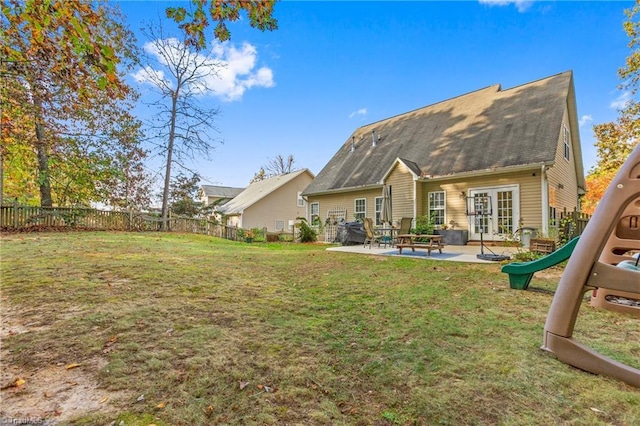 back of house with french doors, a playground, a patio area, and a lawn