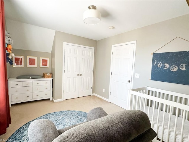 bedroom with light carpet, a closet, and a nursery area