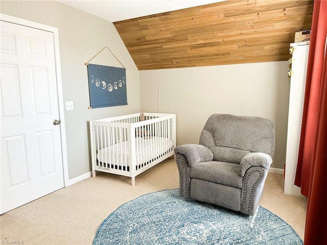 carpeted bedroom with a crib, wooden ceiling, and vaulted ceiling