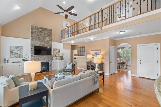 142 Covington Pl, Lewisville, NC 27023 - living room with high vaulted ceiling, a ceiling fan, arched walkways, light wood-style flooring, and a fireplace