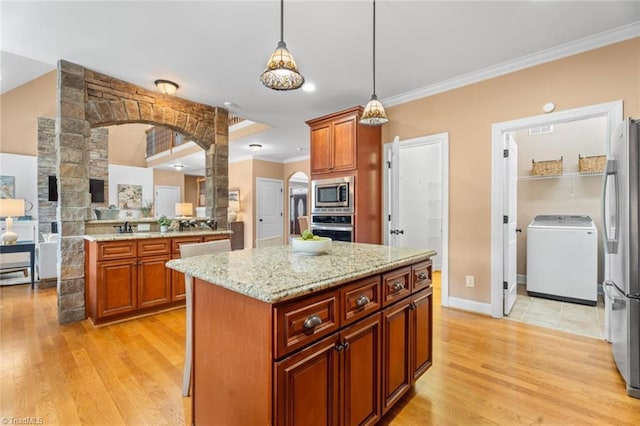 142 Covington Pl, Lewisville, NC 27023 - kitchen featuring appliances with stainless steel finishes, washer / dryer, ornamental molding, arched walkways, and light wood-type flooring