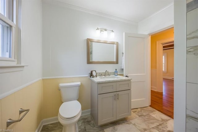 bathroom featuring hardwood / wood-style floors, vanity, toilet, and ornamental molding