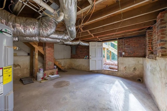 basement with electric water heater and brick wall