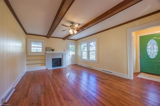 unfurnished living room with hardwood / wood-style flooring, ceiling fan, a healthy amount of sunlight, and beamed ceiling