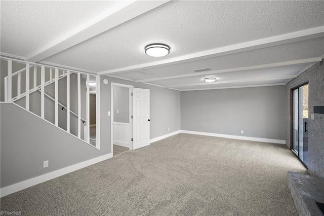 basement featuring a textured ceiling, carpet, and visible vents