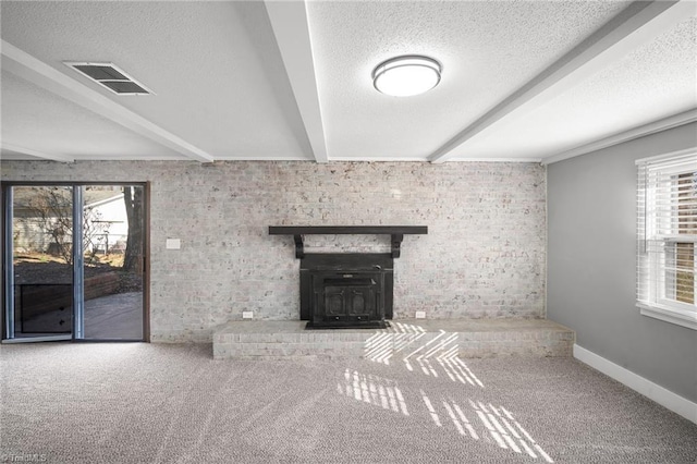 unfurnished living room featuring a textured ceiling, visible vents, beamed ceiling, and a wealth of natural light