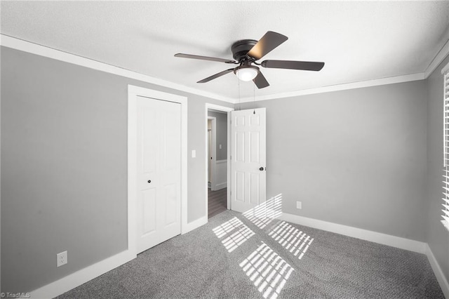 unfurnished bedroom featuring ornamental molding, carpet flooring, and baseboards