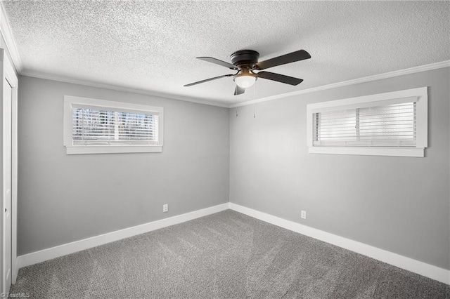 spare room with a ceiling fan, carpet, baseboards, and crown molding