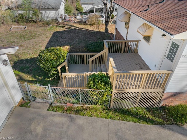 exterior space with a deck, fence, and a gate