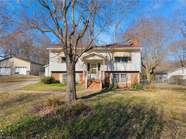 raised ranch with an outbuilding, brick siding, fence, and a front lawn