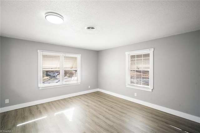 spare room featuring baseboards and wood finished floors