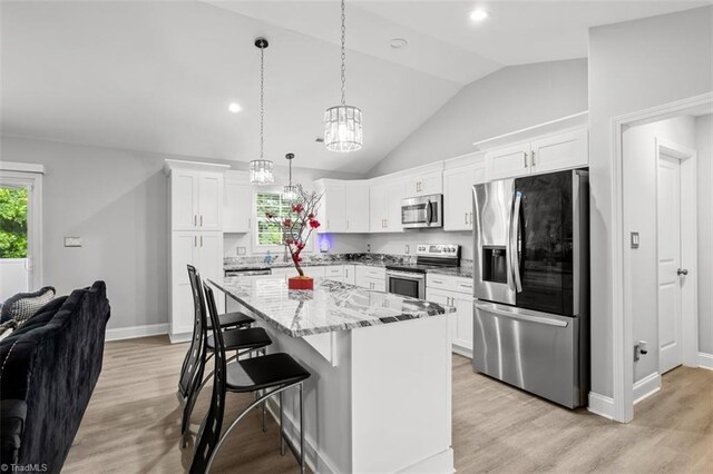 111 Brooke Ridge Dr, Thomasville, NC 27360 - kitchen with appliances with stainless steel finishes, vaulted ceiling, a center island, light stone countertops, and white cabinets