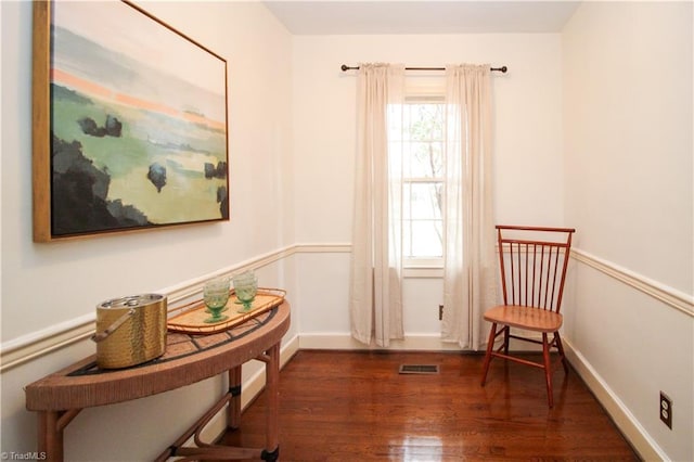 sitting room featuring wood finished floors, visible vents, and baseboards